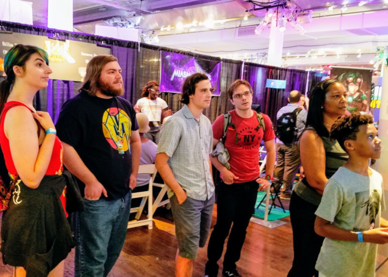 Photo of five people watching a person play Chromavaders